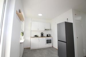 a kitchen with white cabinets and a refrigerator at MOWO Marshall 8 - Apartmenthaus Kitzingen - großzügige Wohnungen für je 6 Personen mit Balkon in Kitzingen +19 photos