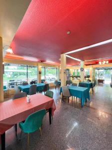 a restaurant with tables and chairs and a red ceiling at Srikij GardenHome Resort in Sa Kaeo