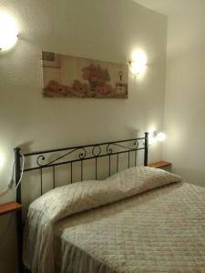 una camera da letto con un letto con due luci sul muro di Costa Rei casa vacanze Gi.&Gi. a Costa Rei