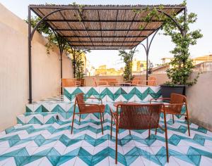 夏卡的住宿－Regina Bianca - Camere, Suite & Spa - Sciacca，铺有瓷砖地板,设有带桌椅的庭院。