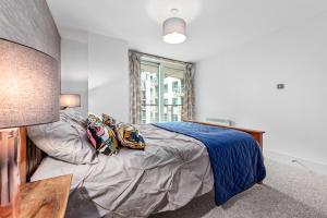 1 dormitorio con cama con sábanas azules y ventana en St, George Wharf Vauxhall Bridge large 2Bedrooms apartment with River View panoramic balcony, en Londres