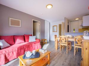 uma sala de estar com um sofá vermelho e uma mesa em Appartement Peyragudes, 2 pièces, 6 personnes - FR-1-695-6 em Germ