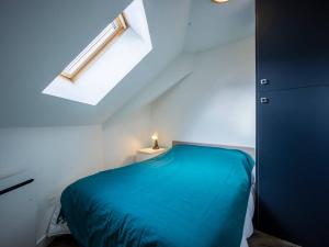 sypialnia z niebieskim łóżkiem i świetlikiem w obiekcie Appartement Peyragudes, 3 pièces, 6 personnes - FR-1-695-20 w mieście Germ