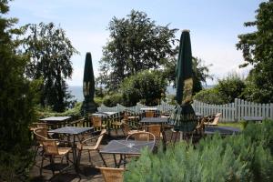 eine Gruppe von Tischen und Stühlen mit Sonnenschirmen in der Unterkunft Hotel Garni Meeresgruß in Sassnitz