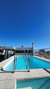 a blue swimming pool with two metal bars in it at Suites Foz O Porto in Porto