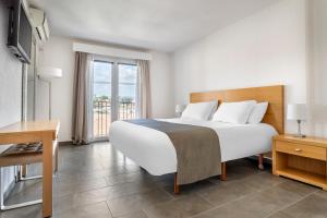 Un dormitorio con una gran cama blanca y una ventana. en Le Club Mougins, en Mougins