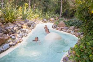 three people swimming in a lazy river in a pool at Hotel Het Heijderbos by Center Parcs in Heijen