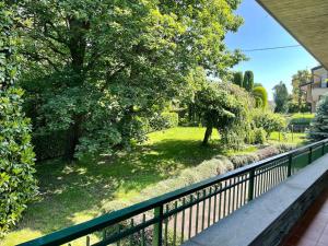 uma vista para um pátio com uma cerca e árvores em Villa Merone - Pusiano Lake em Merone