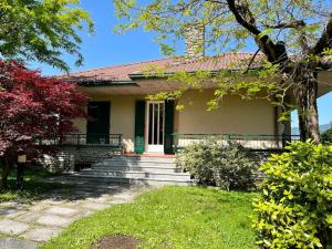 uma pequena casa com escadas e uma porta verde em Villa Merone - Pusiano Lake em Merone