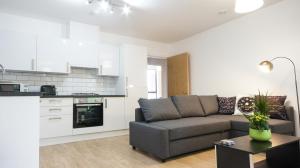 a living room with a couch and a kitchen at Andora Apartments in London