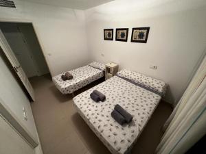 モハカルにあるApartment Annieの壁に2枚の写真が飾られた客室で、ツインベッド2台が備わります。