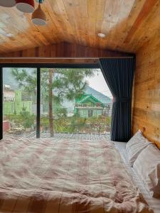 a bedroom with a large bed with a large window at Bách Xanh House Venuestay in Vĩnh Phúc