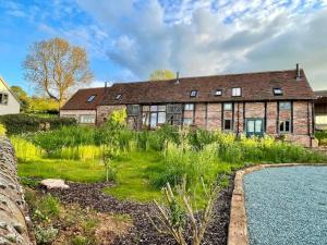 an old brick house with a garden and a swimming pool at The Cart House - Beautiful Contemporary Barn - Hot Tub in Bridgnorth