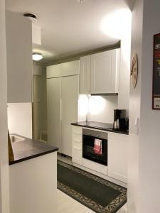 a kitchen with white cabinets and a stove top oven at Top Apartments Helsinki - Alppila in Helsinki