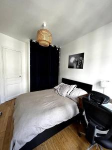 - une chambre avec un lit, un bureau et une chaise dans l'établissement Appartement Confortable et Spacieux Boulogne-Billancourt, à Boulogne-Billancourt