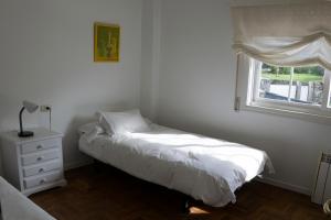 ein kleines Schlafzimmer mit einem Bett und einem Fenster in der Unterkunft Maravilloso apartamento con vistas al mar in Baiona + 7 Fotos