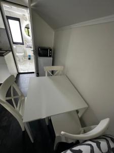 una mesa blanca y sillas en una habitación pequeña en independent apartment near citycenter/lake, en Borås