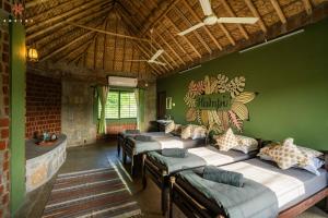 Habitación con 4 camas en una habitación con paredes verdes en Zostel Hampi (Gangavathi), en Hampi