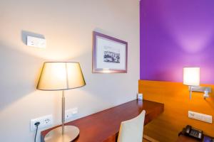 een kamer met een bureau met een lamp erop bij Hotel Salamanca Montalvo in Salamanca