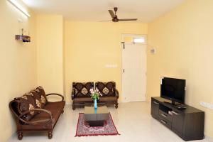 a living room with two couches and a tv at Cozy Haven Luxury Holiday Home in Majorda