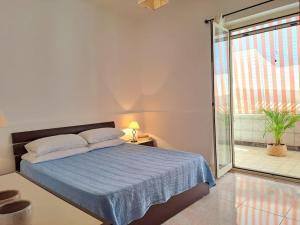 een slaapkamer met een bed en een glazen schuifdeur bij Ambra in Stazzo