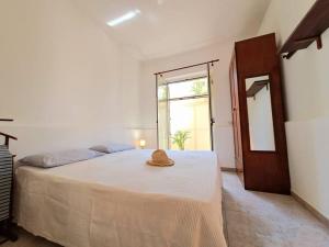 een slaapkamer met een bed met een hoed erop bij Ambra in Stazzo