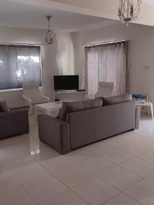 sala de estar con sofá y TV en Anthorina Villa 20, en Protaras