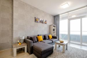 - un salon avec un canapé et une grande fenêtre dans l'établissement Luxury 2BR for 6 with King Beds, Gym, Sauna in JVC, à Dubaï