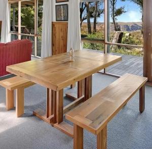 a wooden table and benches in front of a porch at Canyon Cottage Majestic view in Blackheath