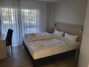 um quarto com uma cama, uma secretária e uma janela em Der Landhof Wolgast em Stolpe auf Usedom