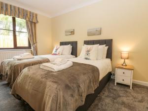 赫克瑟姆的住宿－Pinegarth，一间卧室设有两张床和窗户。