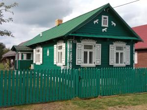 ein grünes Haus mit einem grünen Zaun in der Unterkunft Zielony Domek Plutycze in Plutycze