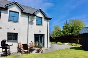 a house with a table and chairs in the yard at Kilmuir Cottage in Tomintoul