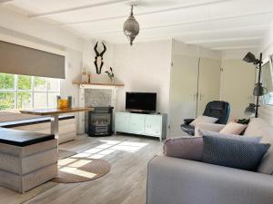 a living room with a couch and a table at Chalet 513 op Recreatiepark De Wielen in Sint Maarten