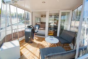 uma sala de estar com uma mesa e cadeiras num barco em Hausboot em Hennigsdorf
