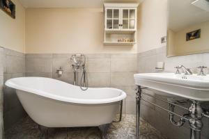 a bathroom with a tub and a sink at Royal Bliss Apartment - Old Town with 2 bedrooms in Bratislava