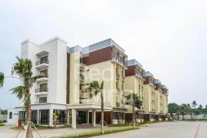 a building with palm trees in front of it at RedLiving Apartemen EcoHome - DeLouvre Tower A Suginoki in Nalagat