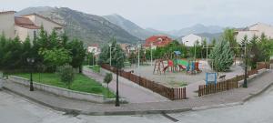 a park with a playground with a fence and trees at Vagelis 2 Nemea apartments in Neméa