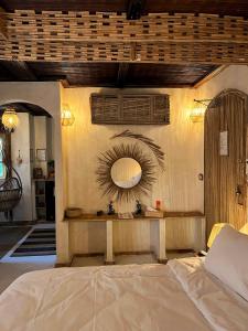 a bedroom with a bed and a mirror on the wall at IL CAMPO Ecolodge & Boutique Hotel in Cairo