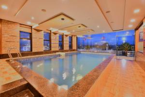 a large swimming pool in a building with a large window at Click Hotel Sagar Plaza Chakan, Pune in Chakan