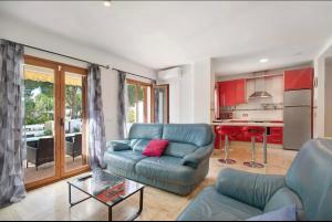 uma sala de estar com um sofá azul e uma cozinha em Carrajolilla Sancti petri em Chiclana de la Frontera