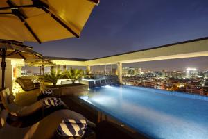 a swimming pool on top of a building with a city skyline at Turyaa Chennai - OMR IT Expressway in Chennai
