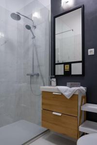 Un baño con ducha, lavabo y espejo. en Studio MAYA, en Maribor