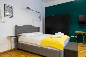 a bedroom with a large bed with a yellow blanket at Studio MAYA in Maribor