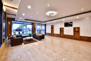 a lobby with couches and a flat screen tv at Click Hotel Sagar Plaza Chakan, Pune in Chakan