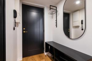 a hallway with a black door and a mirror at Tempus Te Premium Duo Lofts Tartu - private cinema, gym and terrace in Tartu