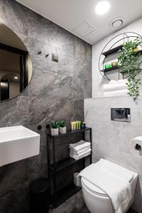 a bathroom with a sink and a toilet and a mirror at Tempus Te Premium Duo Lofts Tartu - private cinema, gym and terrace in Tartu