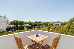 una mesa y sillas en un balcón con vistas en Pinheirinha Guest House en Alpiarça