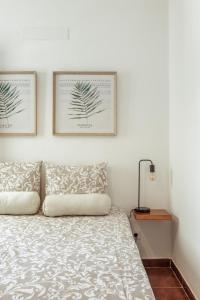 1 dormitorio con 1 cama y 2 cuadros en la pared en Pinheirinha Guest House en Alpiarça