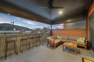 a patio with a couch and a bar with stools at Railway Motel Myrtleford in Myrtleford